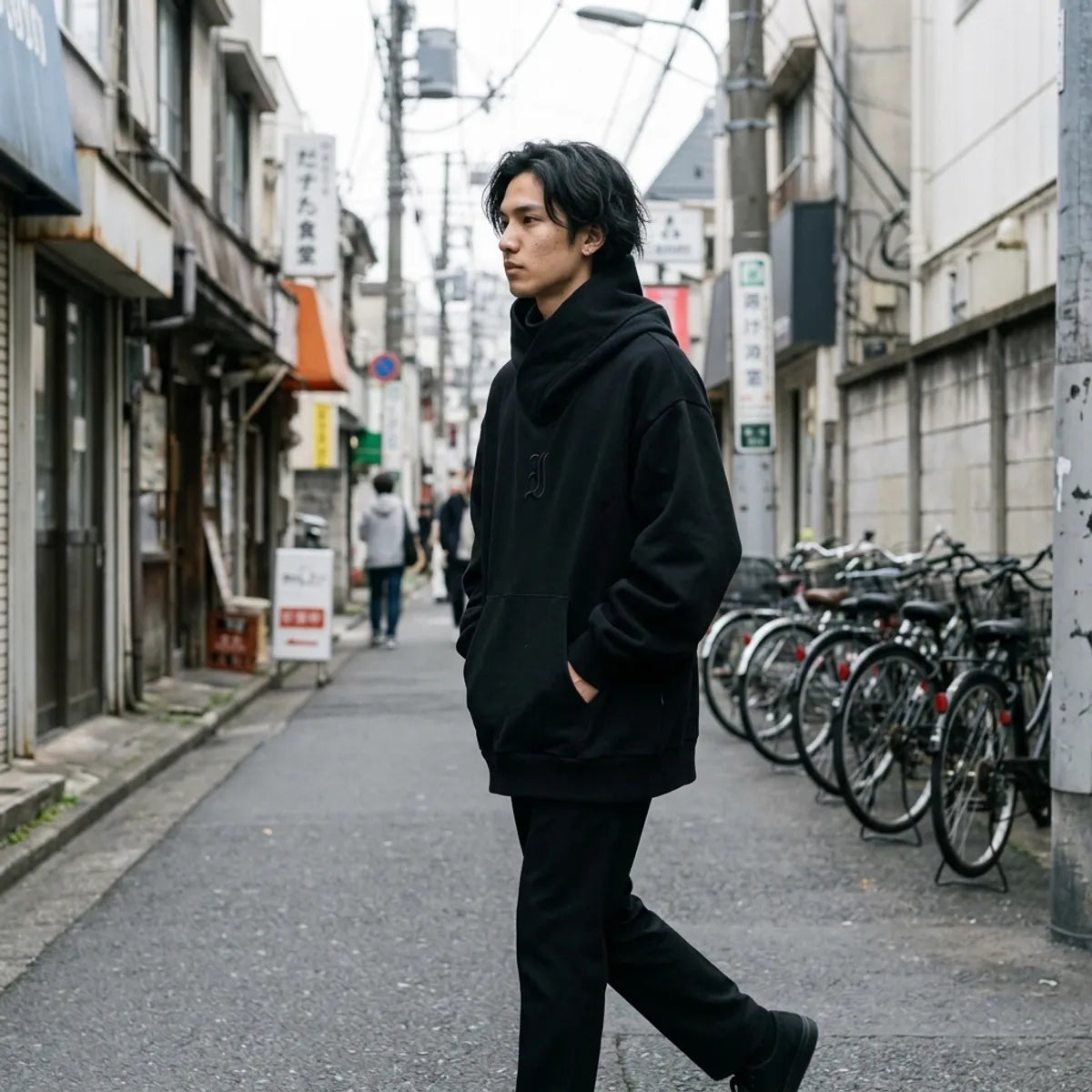 Black oversized hoodie for men, the dropped shoulders and wide sleeves caught while walking in Harajuku