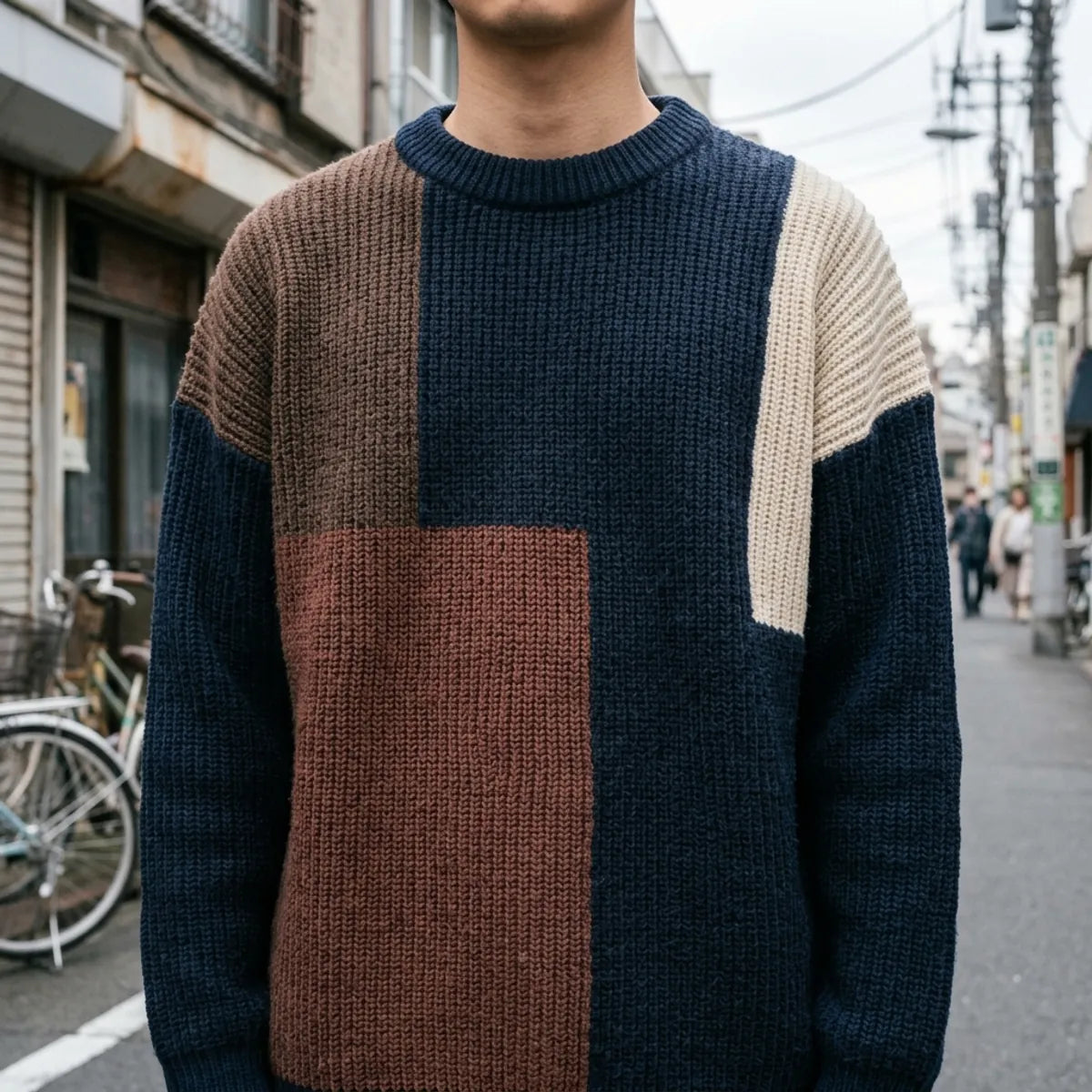 Close view of the ribbed crew neckline and chunky knit texture in navy and chocolate tones