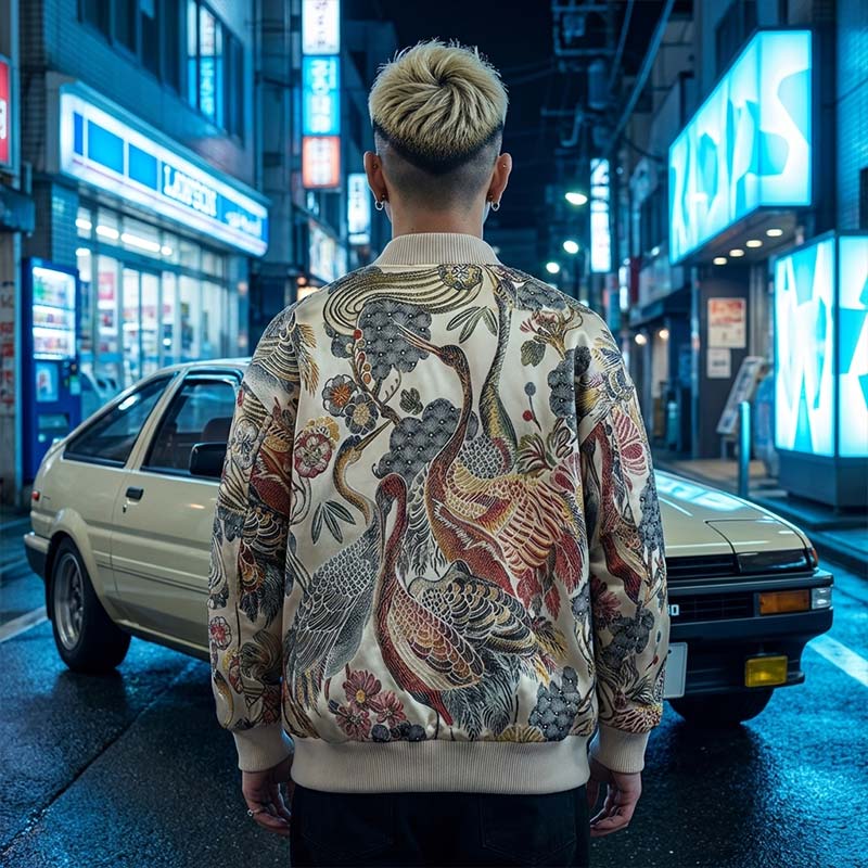 Person wearing an embroidered japanese bomber jacket in a Harajuku neon-lit urban street