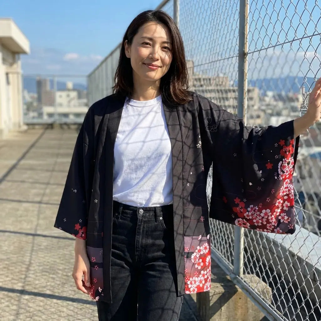 The fox spirit haori in black, photographed on a rooftop beside a wire fence.