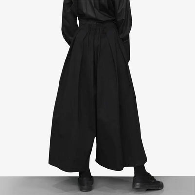 These fashionable hakama pants women modern skirtare black. The woman is dressed in black shoes for a Japanese techwear and urban style.