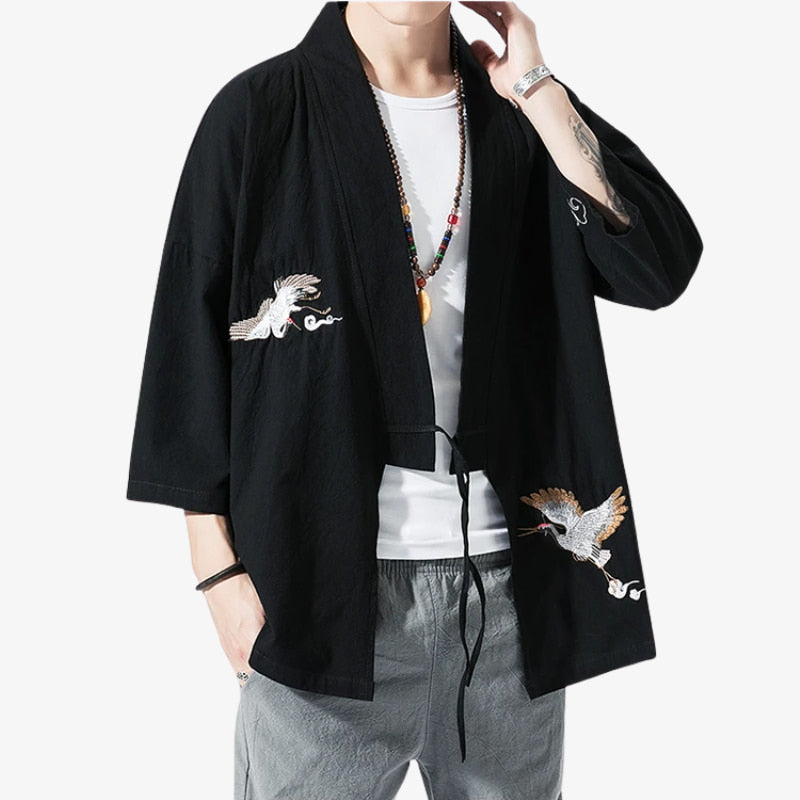 Person wearing a black kimono Haori for Men with Japaense bird embroidery on a white background. This Japanese symboles is named a crane