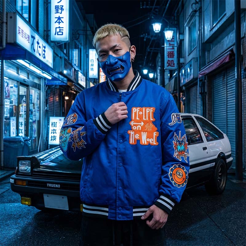 Person wearing a blue japanese bomber jacket with colorful designs on a Tokyo neon-lit street. He s also wearing a blue half samurai mask