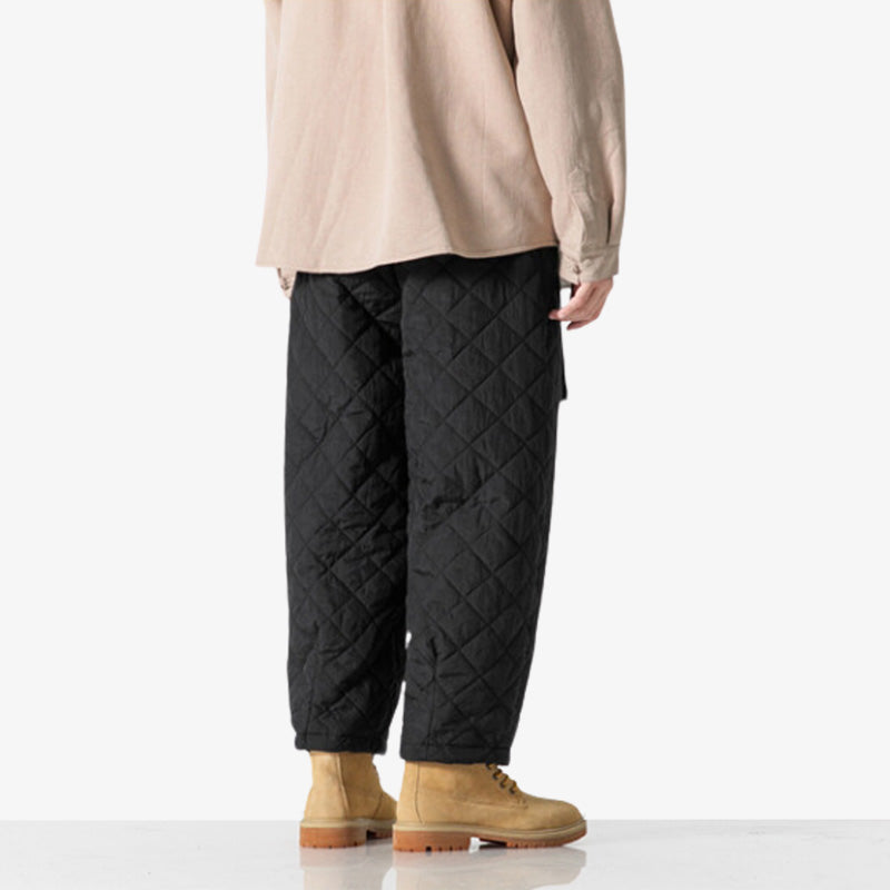 A man standing and dressed with japanese cargo pants streetwear. With cream jacket and yellow shoes