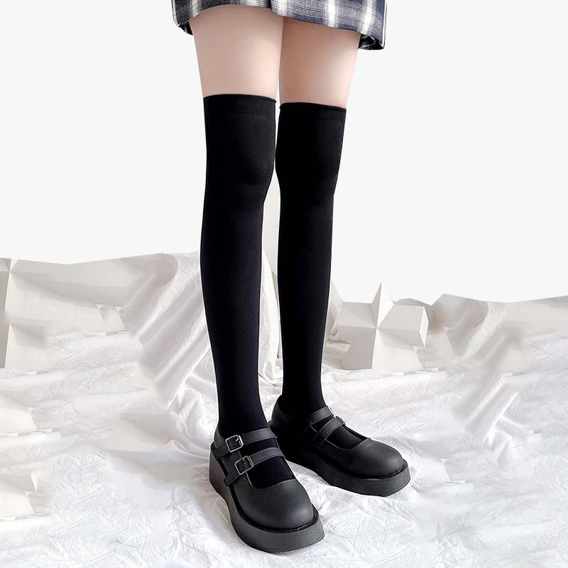 A girl is wearing a pair of Japanese fashion long sockssocks with schoolgirl shoes and a checked skirt.