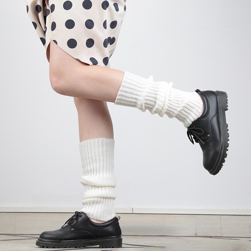 A girl is dressed with a lolita skirt, and japanese long loose socks. Material is cotton and the Japanese socks color is white. The japanese girls has black student shoes on her feet