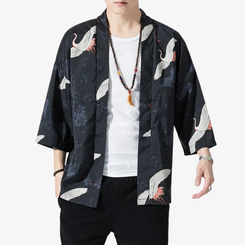 Person wearing a japanese men's kimono jacket with white crane designs on a white background