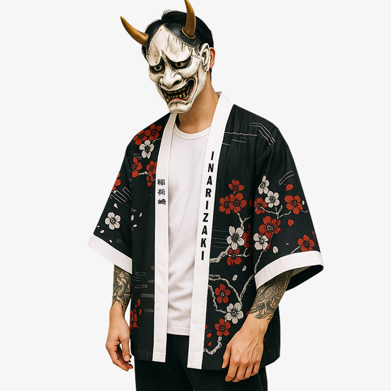 a man is dressed with kimono fox. The black haori jacket is printed with flower sakura. He also wear a traditional hannya mask on his face for his japanese outfit