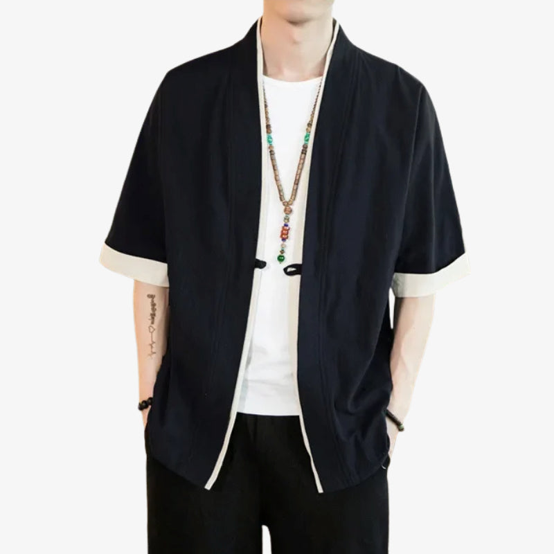 Person wearing a kimono haori black jacket with white trim on a white background