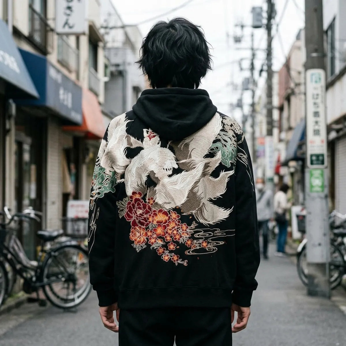 The back of the kitsune fox hoodie: a large white nine-tailed fox above red peonies and orange blossoms