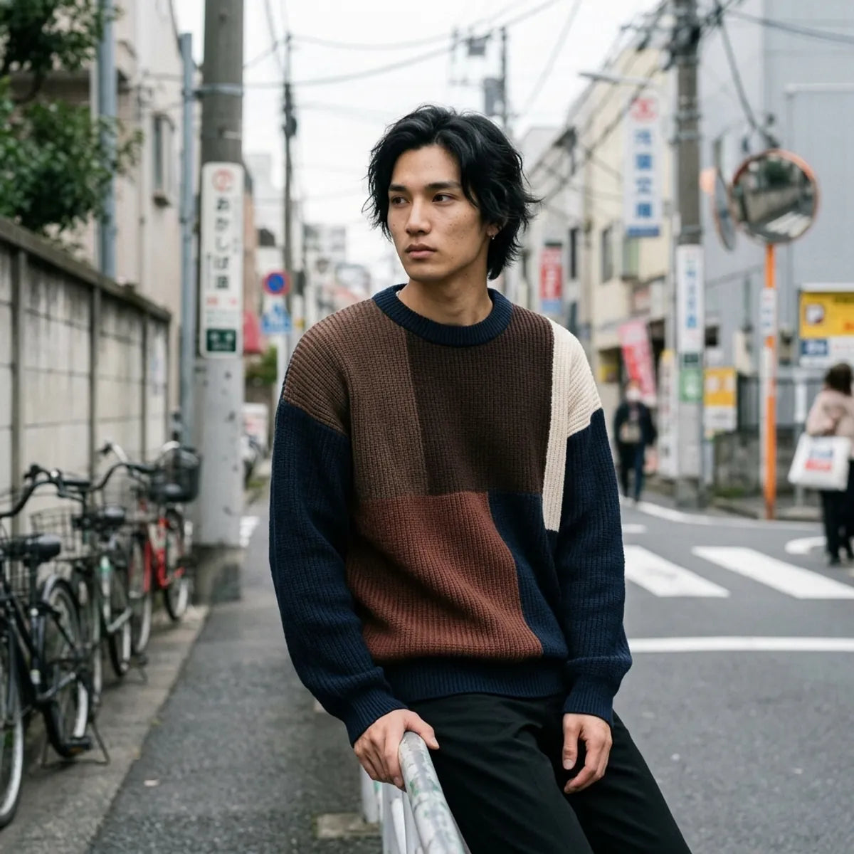 Navy knit sweater with colorblock design laid flat showing the drop shoulder silhouette