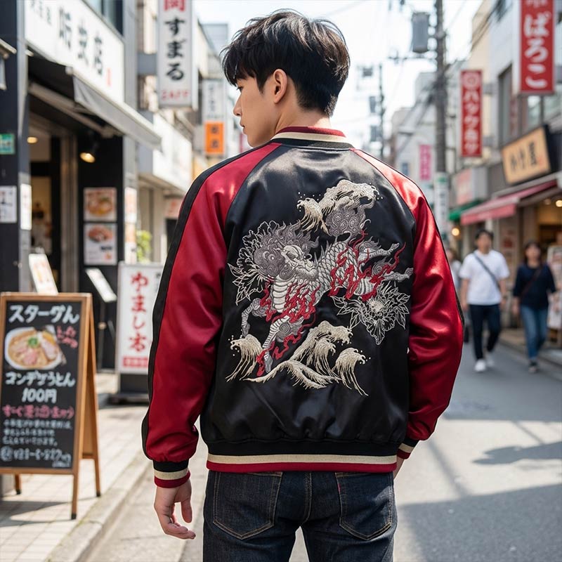 Person wearing a black and red embroidered jacket with a Japanese Kirin design on a city street.