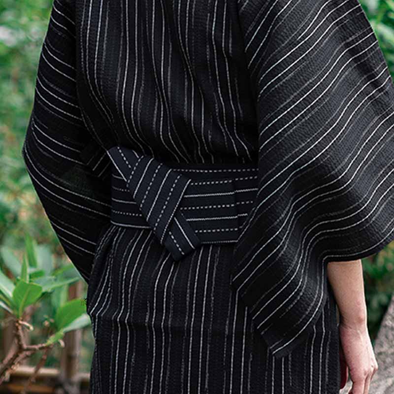 A traditional Japanese belt men man ties a kimono made with coton and black color