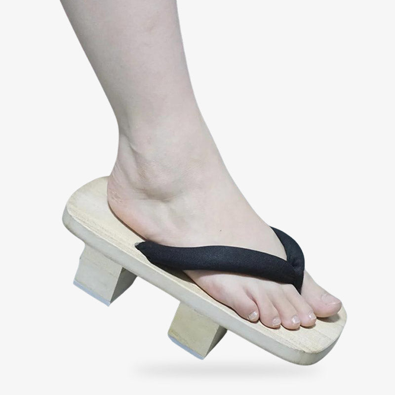 Slip your feet in the traditional japanese sandals geta handmade with wood and black straps