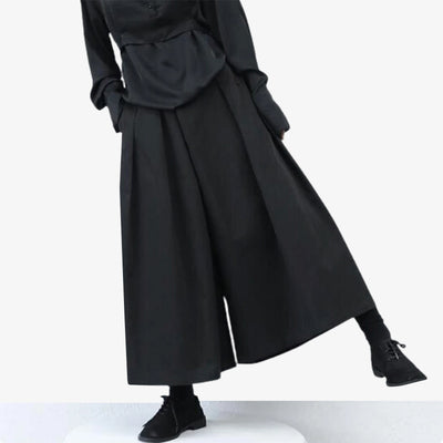 The women hakama pants are black. This traditional Japanese garment is perfect for a techwear look or Japanese streetwear style.