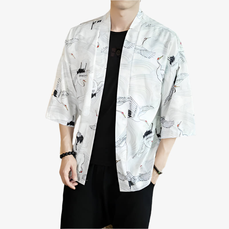 Person wearing a white kimono cranes patterns with a black t-shit round neck and a black pants