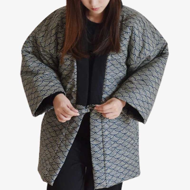 A person wearing a traditional Japanese hanten vintage with a seigaiha pattern, which is grey and black, tied at the waist.