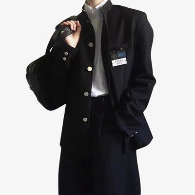A man standing is dressed with a Black Japanese Schoolboy uniform. He also wears a white shirt