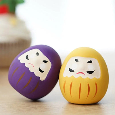 There are two japanese daruma doll purle and yellow. Use it as a Japanese home decor to bring luck