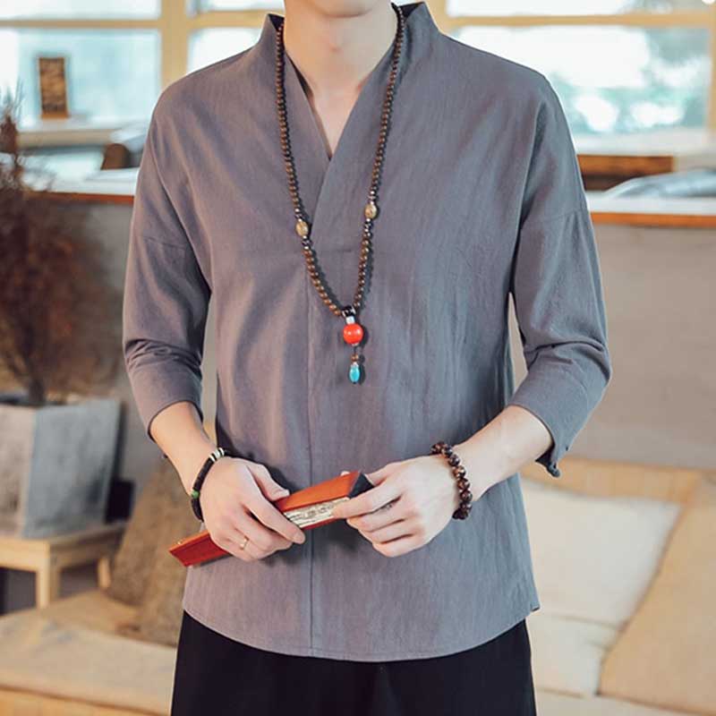 A man dressed with a Japanese grey traditional shirt. He has a necklace