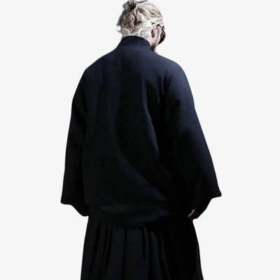 A Japanese man from the back is dressed in a long black Japanese kimono coat for men