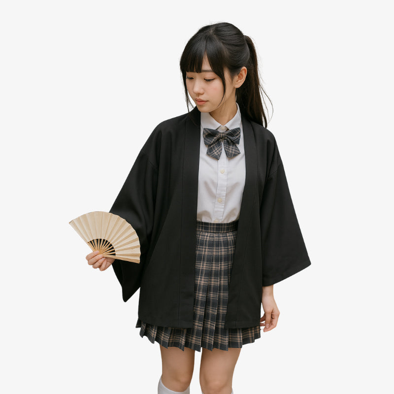 Woman in a traditional Japanese outfit with a black kimono and plaid skirt, holding a wooden fan.