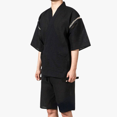 A person wearing a traditional Modern Jinbei clothing, which is a short kimono set, in black color with fine stripes and decorative details on the sleeves.