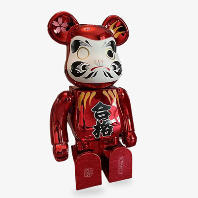 The bearbrick red Daruma features a traditional red Daruma design with a kanji symbol, representing luck, perseverance, and the pursuit of personal goals in Japanese culture.