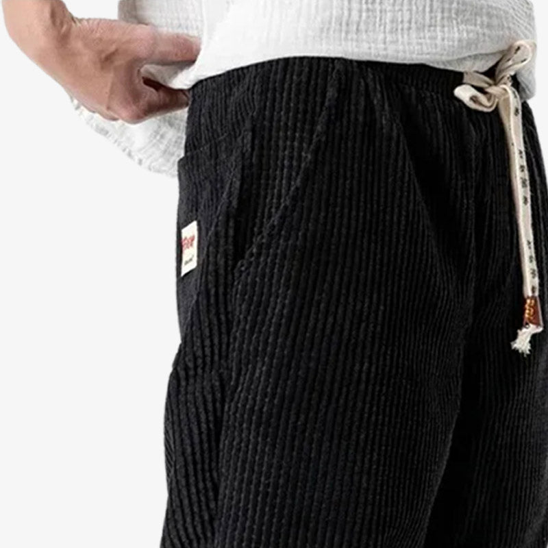 Black corduroy pants outfit paired with modern Japanese streetwear for a casual yet refined look.