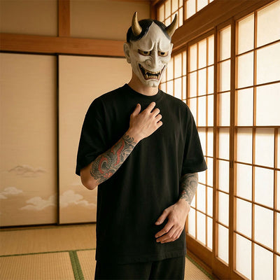 Person wearing a traditional Japanese mask in a room with shoji screens and a black harajuku shirt round neck