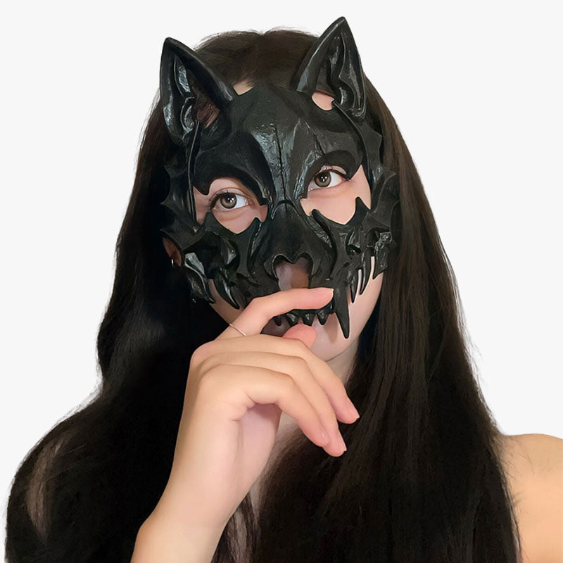 A women has a full black japanese kitsune mask onf the face