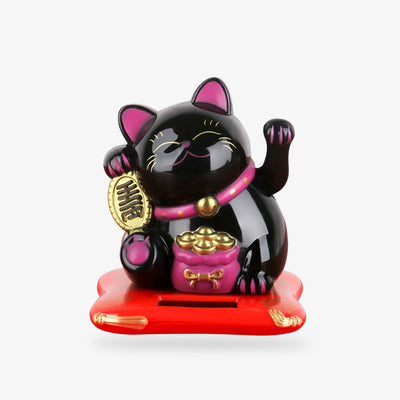 This black Maneki Neko cat is a Japanese lucky charm. The black cat is holding a Koban coin. It has a pink collar and a coin bag. The lucky cat's left paw is raised for good luck and fortune.