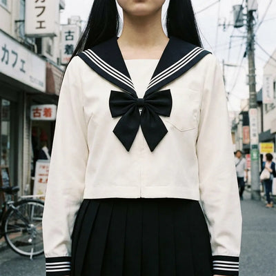 Close view of the black bow ribbon and striped navy cuffs on the sailor blouse