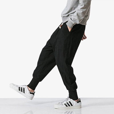 A Japanese man wears black streetwear pants with adidas sneaker and a grey sweatshirt