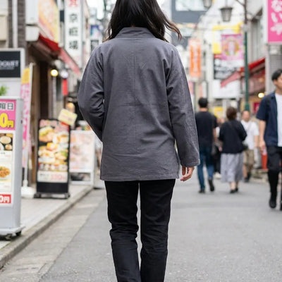 Woman seen from behind wearing a traditional japanese samue in a Harajuku street