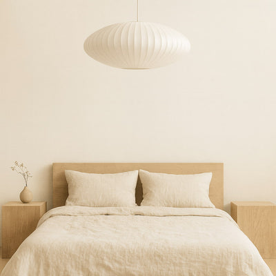 Beige bedroom with a bed, nightstands, and a Chandelier Japanese pendant light.