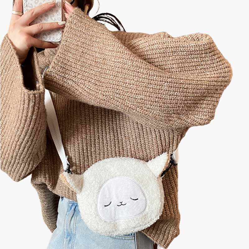 A Japanese woman has a cute handbag kawaii on her shoulder. It's a white fleece bag that looks like a cute little sheep.