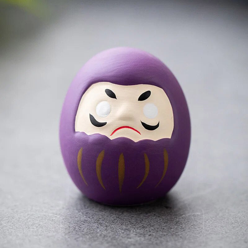 The Daruma Doll purple is japanese statue painted wiht white, red and purple color. Material used is ceramic