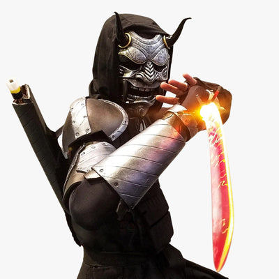 A man is wearing a demon face mask, a katana and a helmet. It s a unique handmade creation, crafted from fiberglass and wood, with horns and sharp teeth, each mask telling a story from Japanese mythology