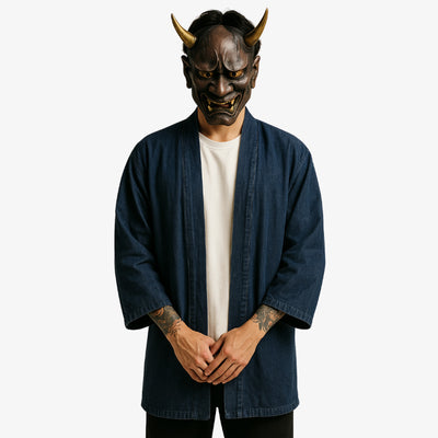 a japanese mam is dressed with a denim kimono, a white harajuku shirt made with cotton and a black japanese pants. His face is hidden by a red traditional Hannya mask