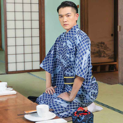 A japanese man wear a dress kimono for men. kimono for men is attached with an obi belt. Color kimono is blue
