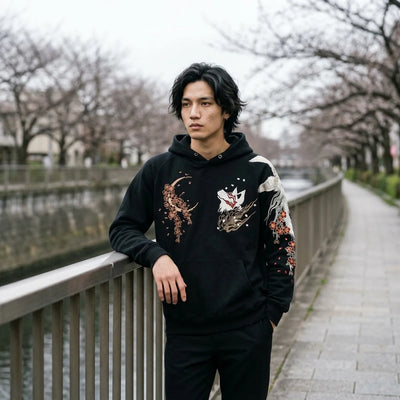 The embroidered kitsune pullover worn beside the Meguro river in Tokyo under a grey sky