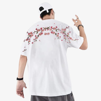 Person wearing a white floral embroidered shirt with floral designs on the back, posing against a white background.
