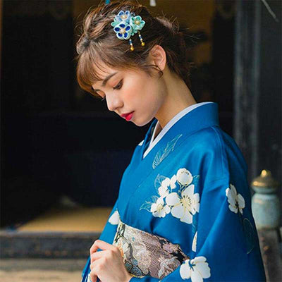 Flower kimono dress adorned with beautiful floral patterns. A woman is elegantly dressed in this traditional Japanese kimono, showcasing the intricate flower prints. The women has a japanese flower Kanzashi attached on her hair