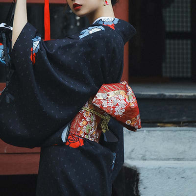 a japaonese woman is dressed with geisha kimono obi belt made with cotton and red color. The japanese belt is embroidered with floral traditional Japanese patterns