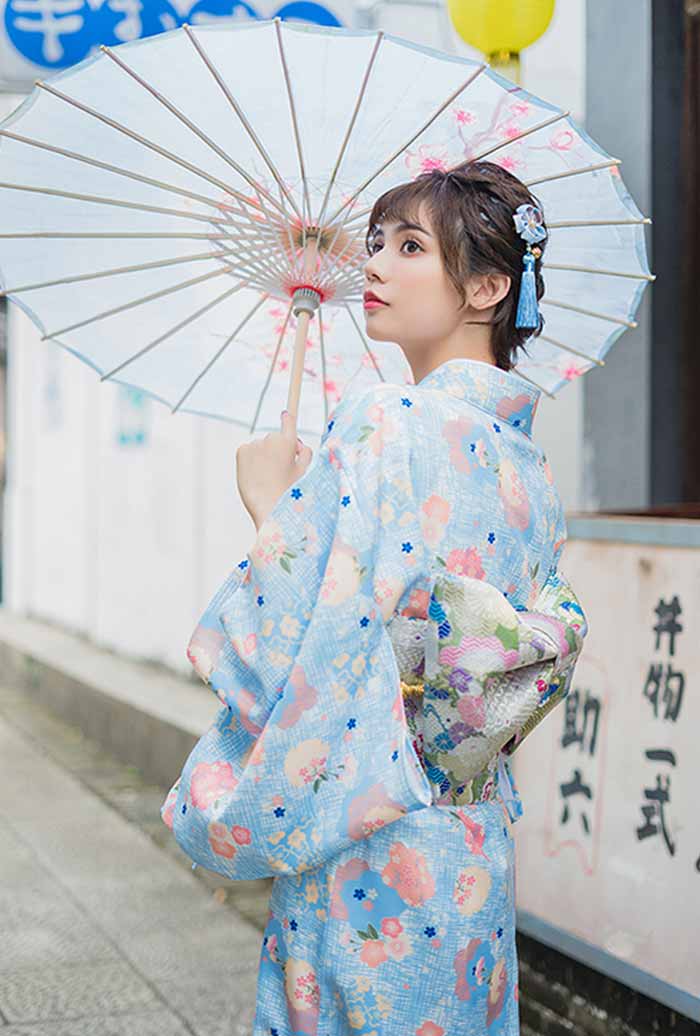 Geisha kimono robe traditional style, featuring beautiful Japanese floral motifs. The woman holds a wagasa, adding to the elegance of her attire