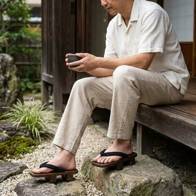 Geta Japanese Man sandals worn with white tabi socks in a Japanese garden