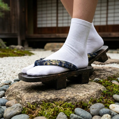 Close-up of navy hanao strap with golden dragon motif on geta sandals