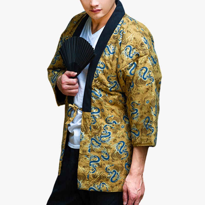 A person wearing a traditional Japanese hanten Tokyo coat with golden yellow background and blue dragon motifs, holding a black fan.