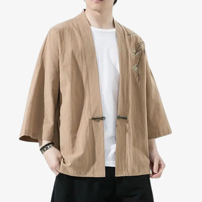Person wearing a beige haori kimono jacket embroidered with bamboo floral pattern on a white background